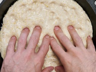 Pressing out sourdough pizza dough to fit skillet.
