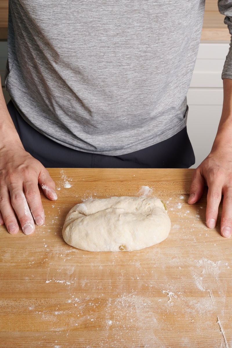 The second step to shaping filoncini is to flip the dough 180° and fold the new top down.