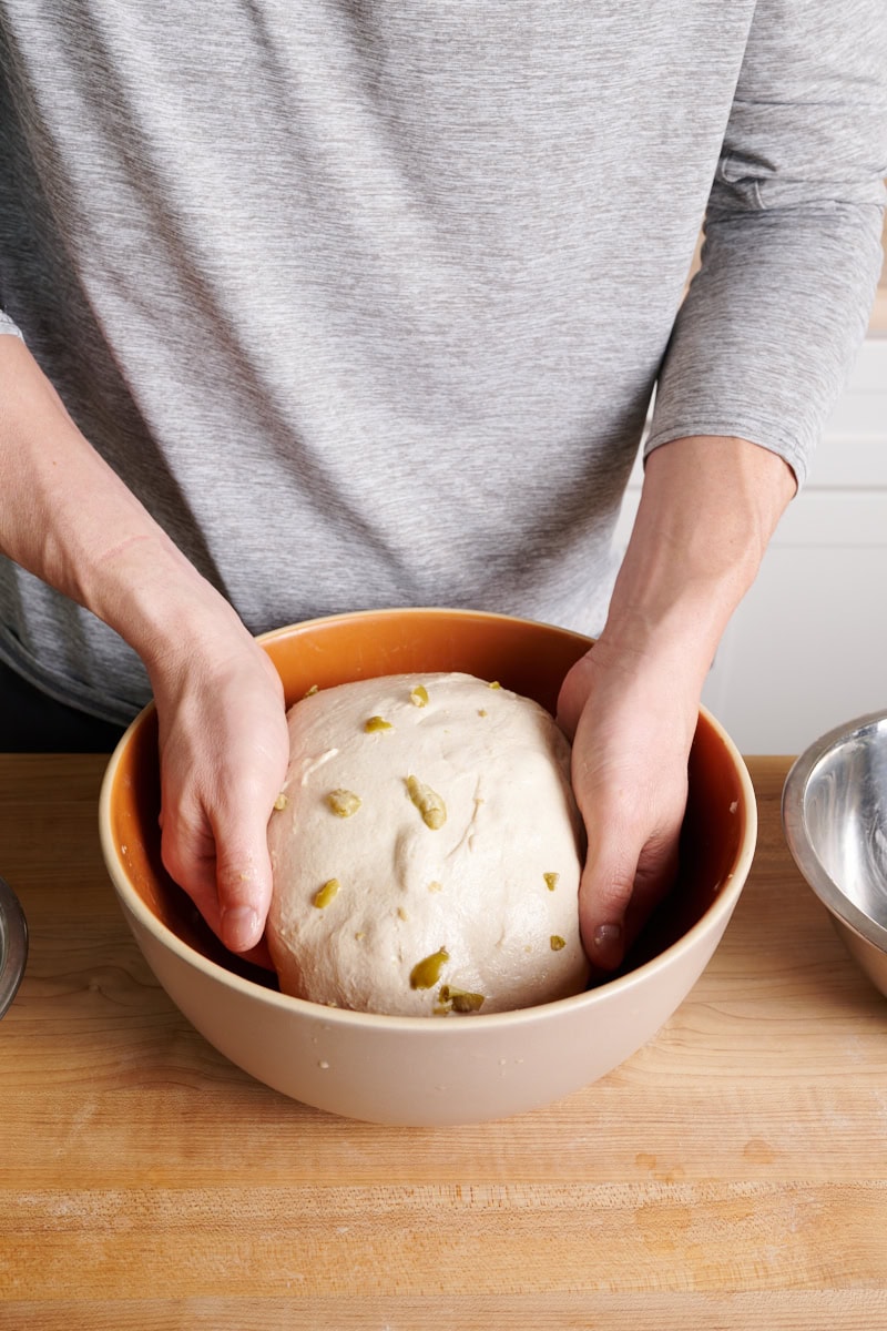 Adding olives to filoncini dough during bulk fermentation.