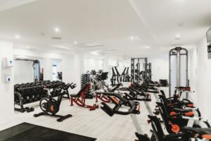 gym full of dumbbells, cardio machines, adjustable benches, and other equipment