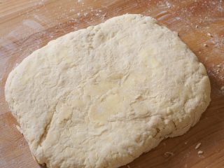 Sourdough biscuit dough patted out to a 1" rectangle.