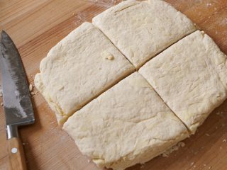 Sourdough biscuit dough cut into quarters.