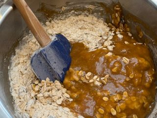 Mixing browned butter and sugar into oat and flour mixture.