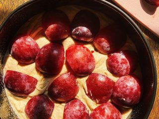 Adding plums to the top of the batter.