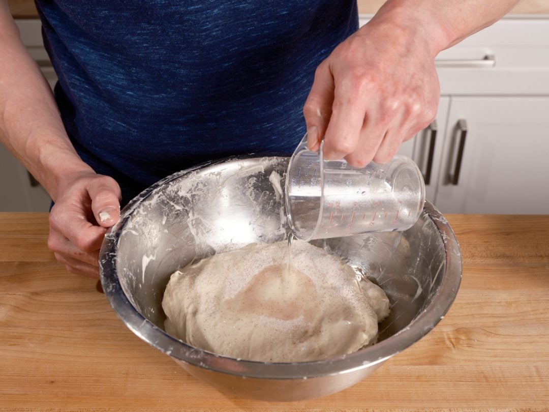 Adding water to sourdough bread dough